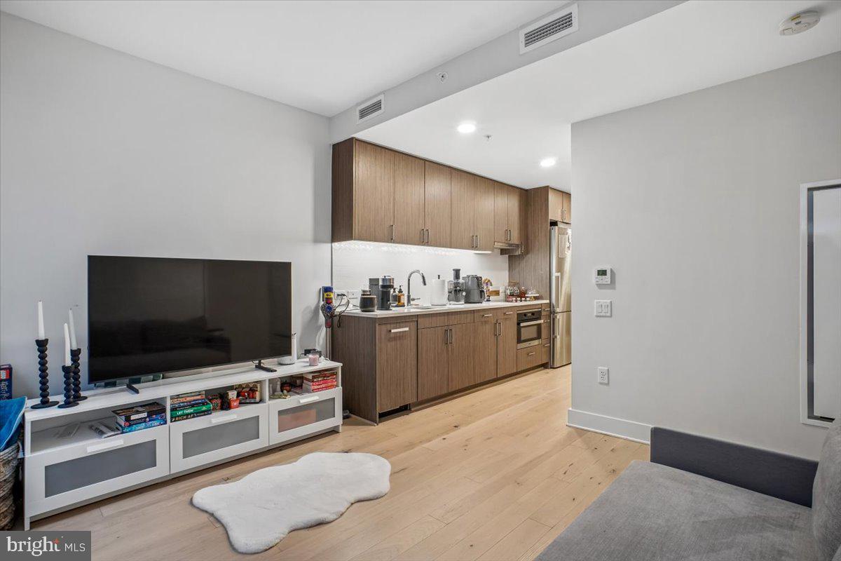1211 Van Street Southeast, Unit 403 Washington, DC 20003 - Photo 12 of 21 a living room with furniture and a flat screen tv