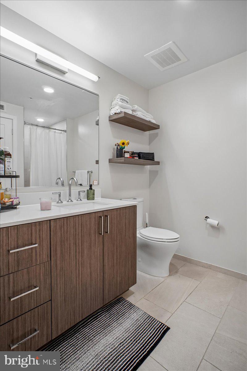 1211 Van Street Southeast, Unit 403 Washington, DC 20003 - Photo 18 of 21 a bathroom with a sink a toilet and a mirror
