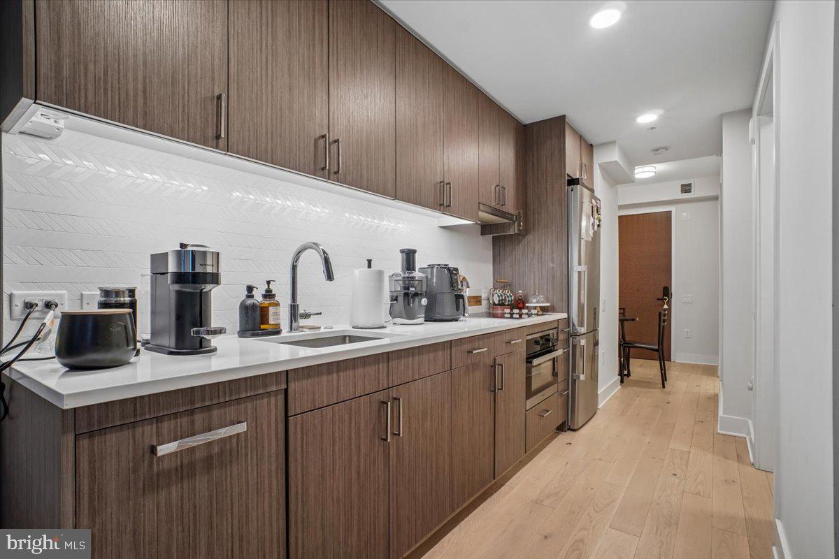 1211 Van Street Southeast, Unit 403 Washington, DC 20003 - Photo 4 of 21 a kitchen with sink a refrigerator and cabinets