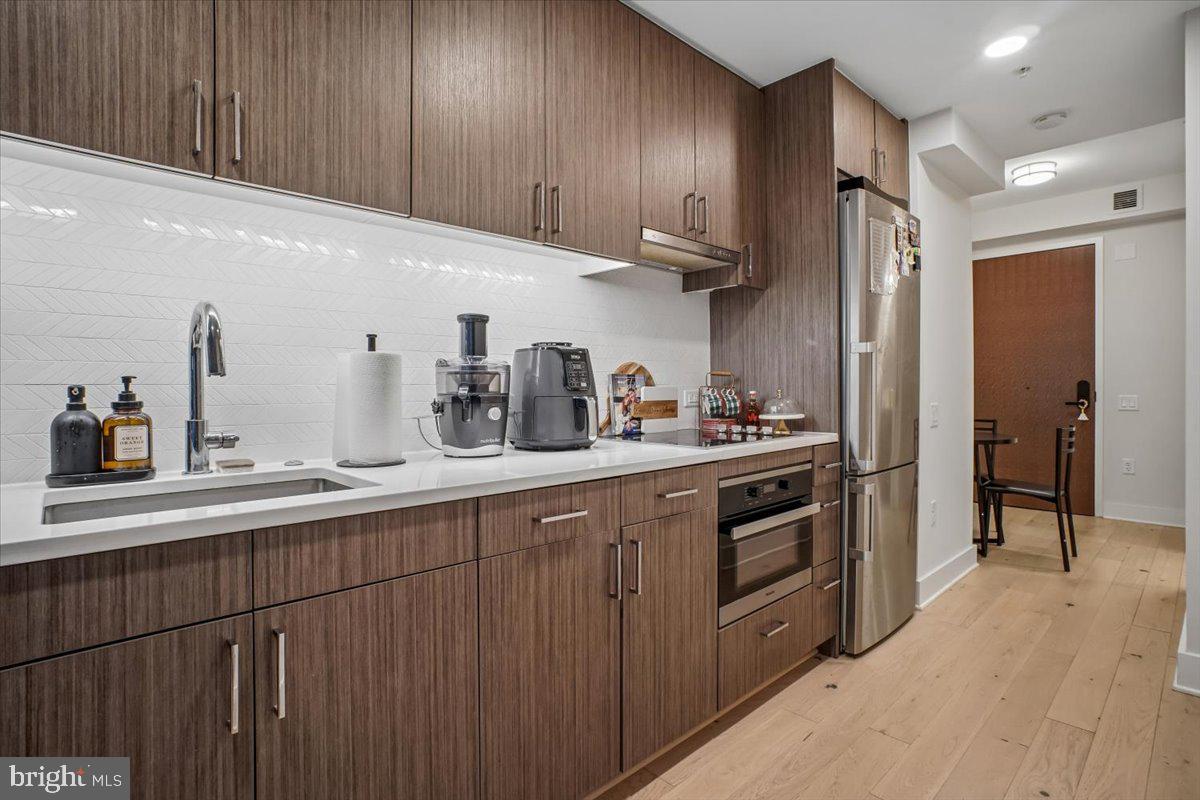 1211 Van Street Southeast, Unit 403 Washington, DC 20003 - Photo 5 of 21 a kitchen with stainless steel appliances granite countertop wooden cabinets a sink and dishwasher