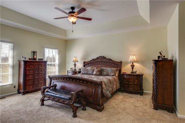 6288 Arno Road Franklin, TN 37064 - Photo 9 of 20 a bedroom with a bed a dresser and a chandelier