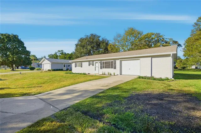 a view of a house with backyard and trees