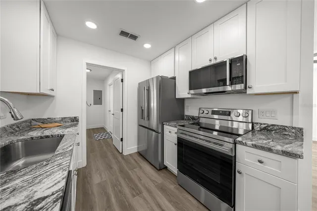 a kitchen with stainless steel appliances a stove a sink a stove a microwave and cabinets