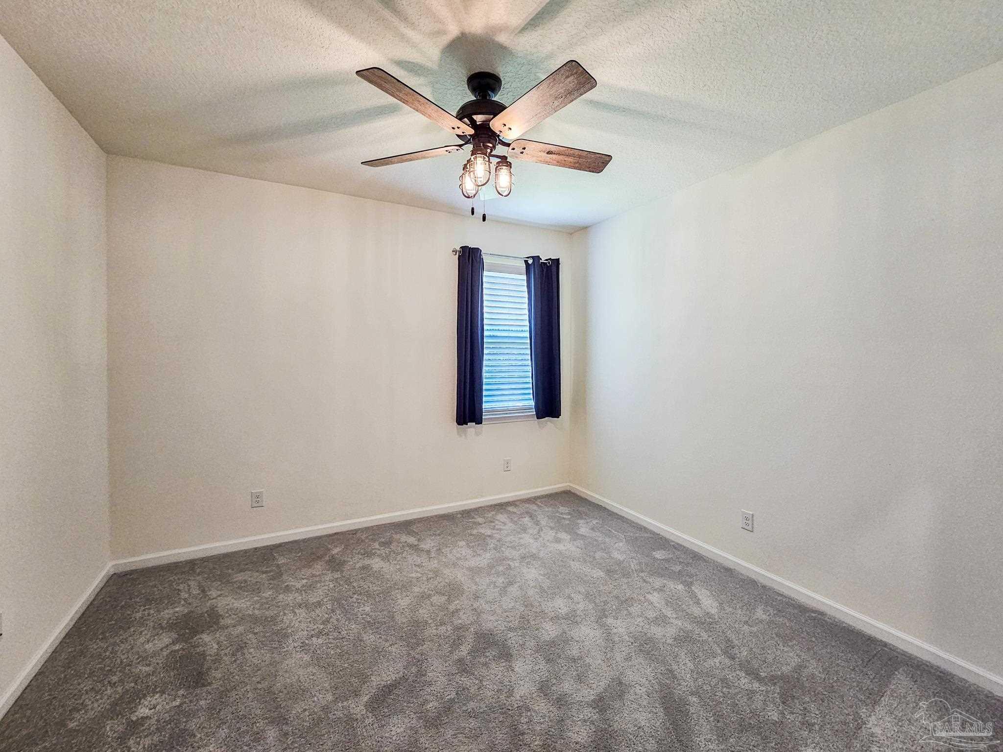 4149 Upper Walk Lane Milton, FL 32583 - Photo 27 of 43 an empty room with windows and chandelier fan