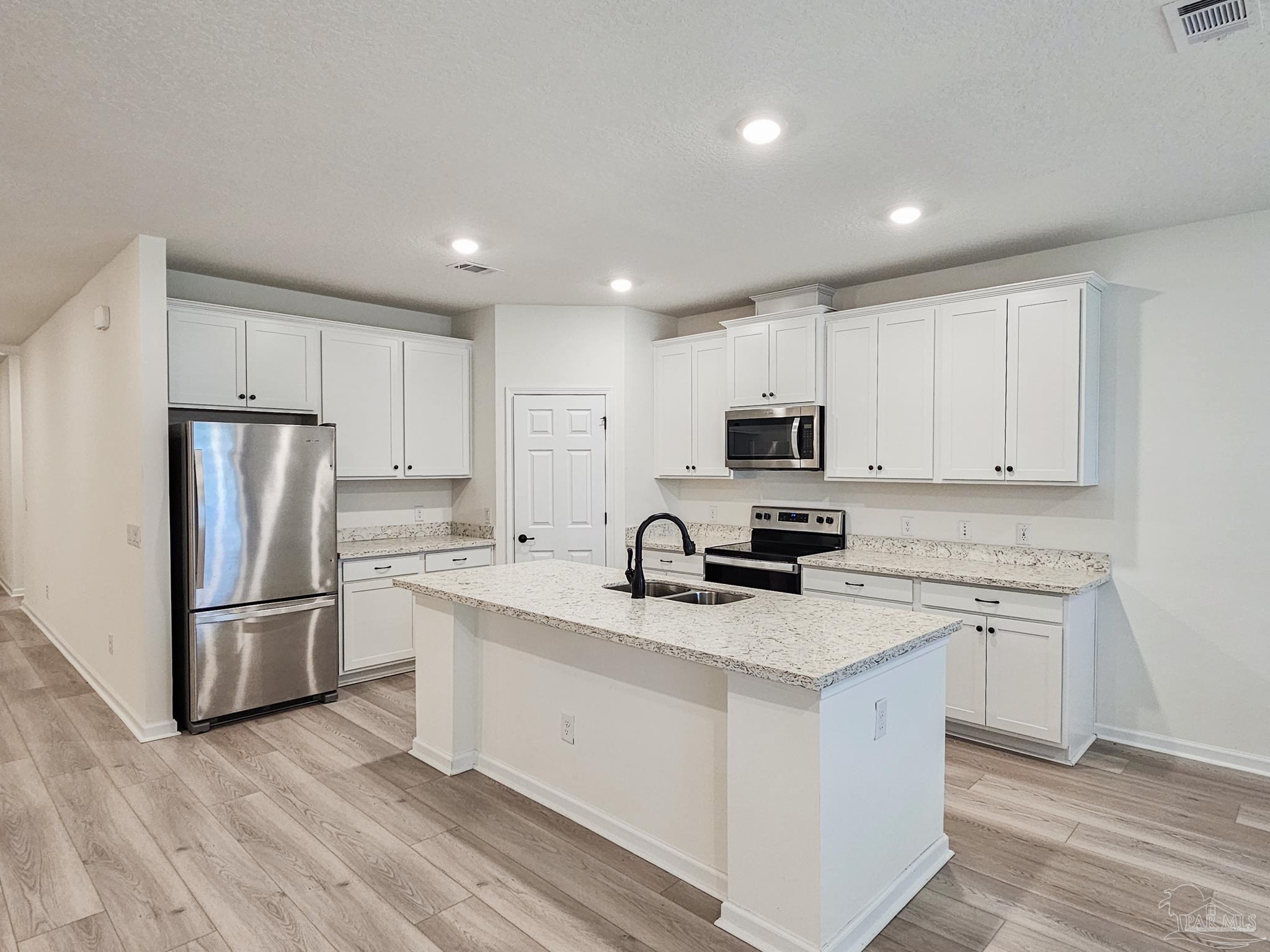 4149 Upper Walk Lane Milton, FL 32583 - Photo 7 of 43 a kitchen with a refrigerator stove microwave and sink