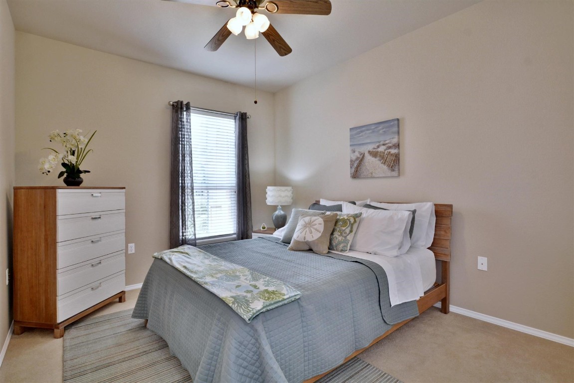 247 Bonham Loop Georgetown, TX 78633 - Photo 12 of 32 a bedroom with a bed and a chandelier
