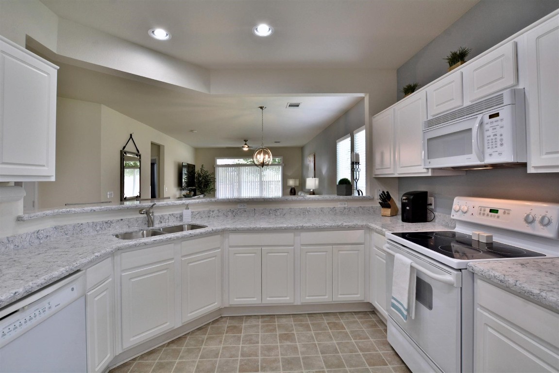 247 Bonham Loop Georgetown, TX 78633 - Photo 20 of 32 a kitchen with a sink stove and cabinets