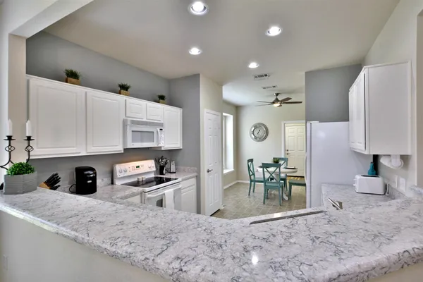 a kitchen with stainless steel appliances granite countertop a sink refrigerator and cabinets