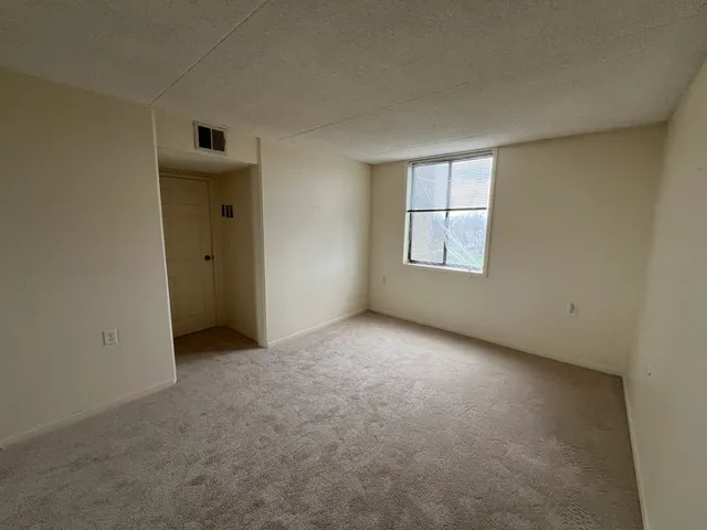 an empty room with windows and closet