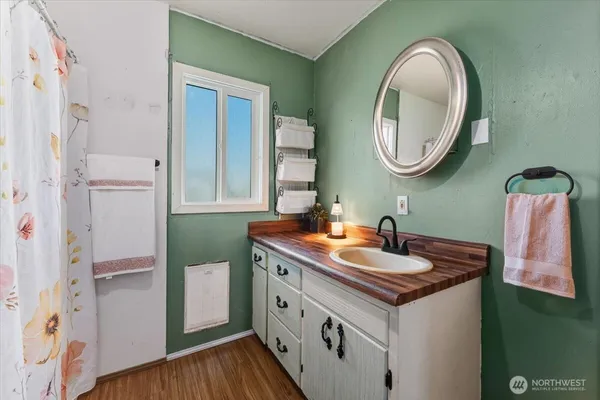 a bathroom with a granite countertop sink a mirror and a toilet