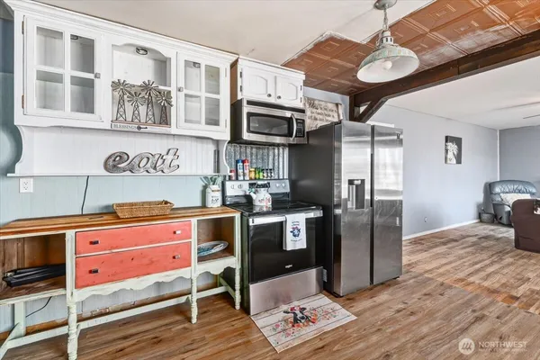 a kitchen with stainless steel appliances granite countertop a stove refrigerator and cabinets