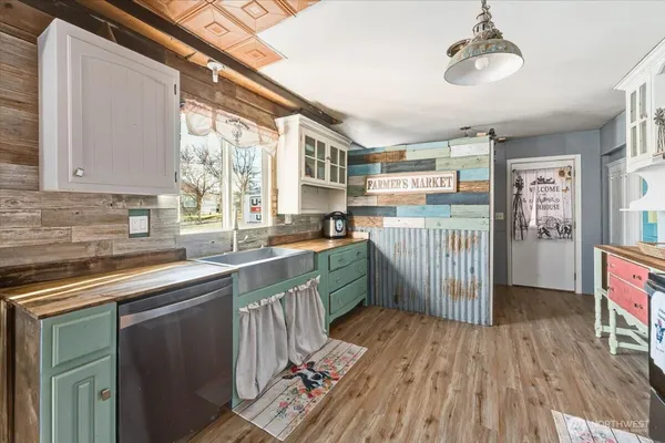 a kitchen with stainless steel appliances granite countertop a refrigerator a sink dishwasher a stove and white countertops with wooden floor