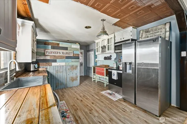 a kitchen with stainless steel appliances granite countertop a refrigerator a sink and wooden cabinets