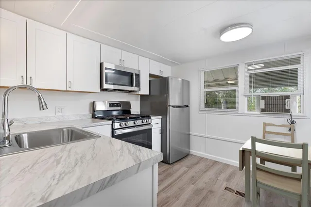 a kitchen with granite countertop a stove a sink and a refrigerator