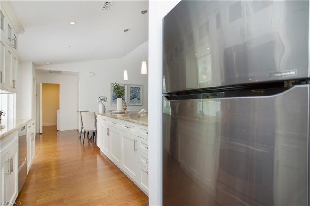 1534 Northgate Drive Naples, FL 34105 - Photo 11 of 50 a kitchen with a refrigerator a sink and cabinets