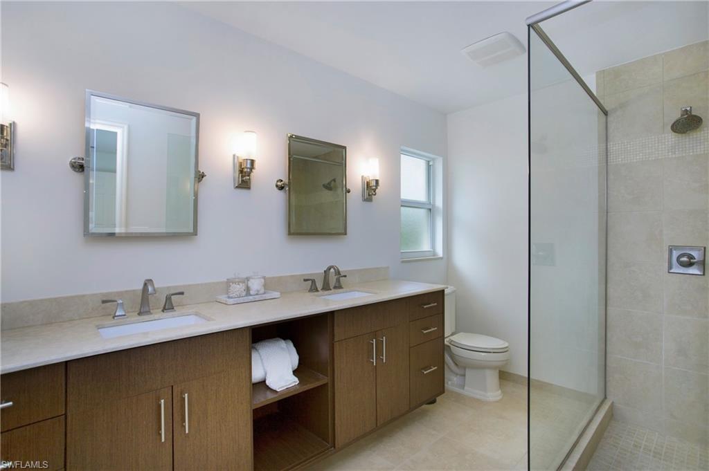 1534 Northgate Drive Naples, FL 34105 - Photo 22 of 50 a bathroom with a double vanity sink and a mirror