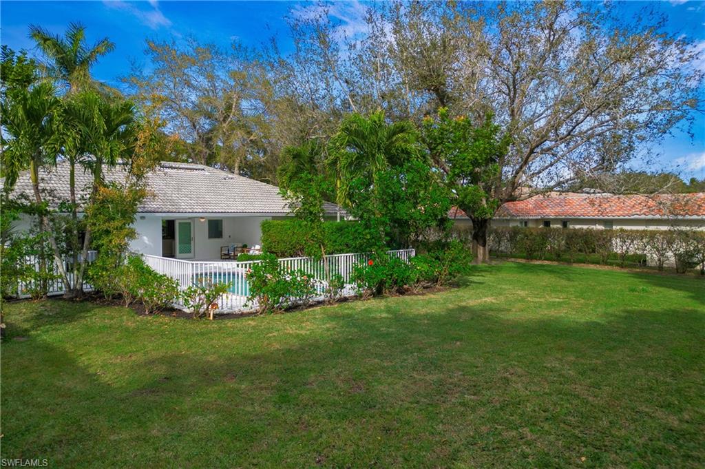 1534 Northgate Drive Naples, FL 34105 - Photo 44 of 50 a front view of a house with a garden and trees