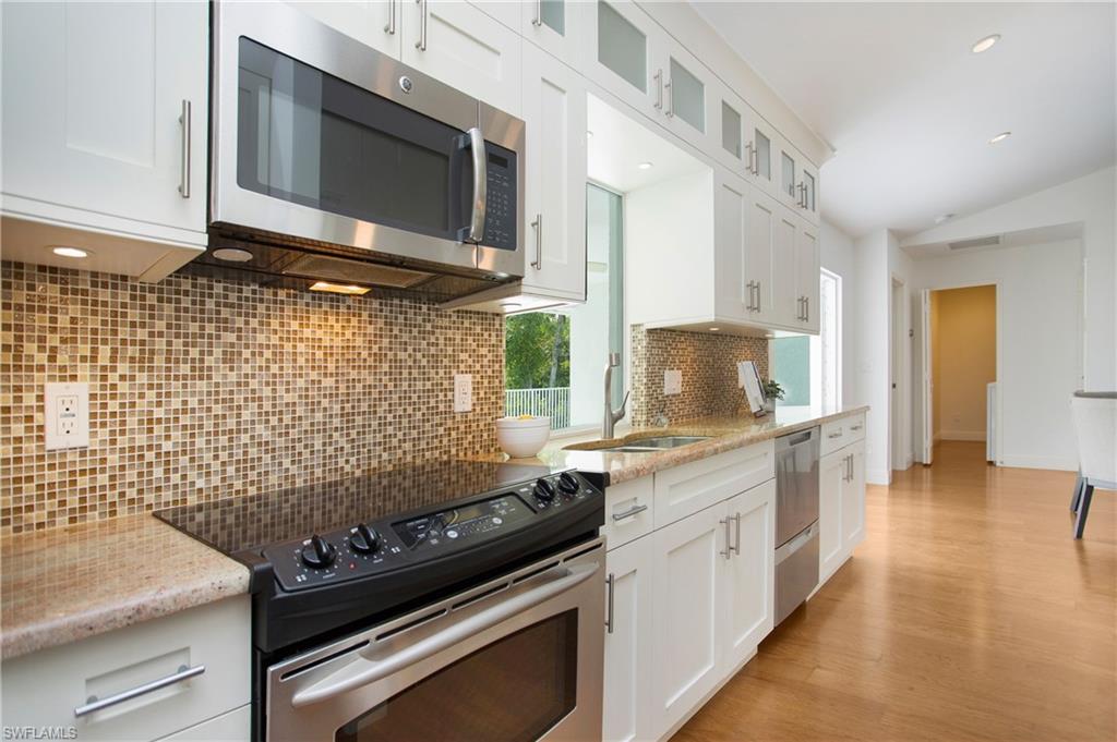 1534 Northgate Drive Naples, FL 34105 - Photo 9 of 50 a kitchen with a stove and a microwave