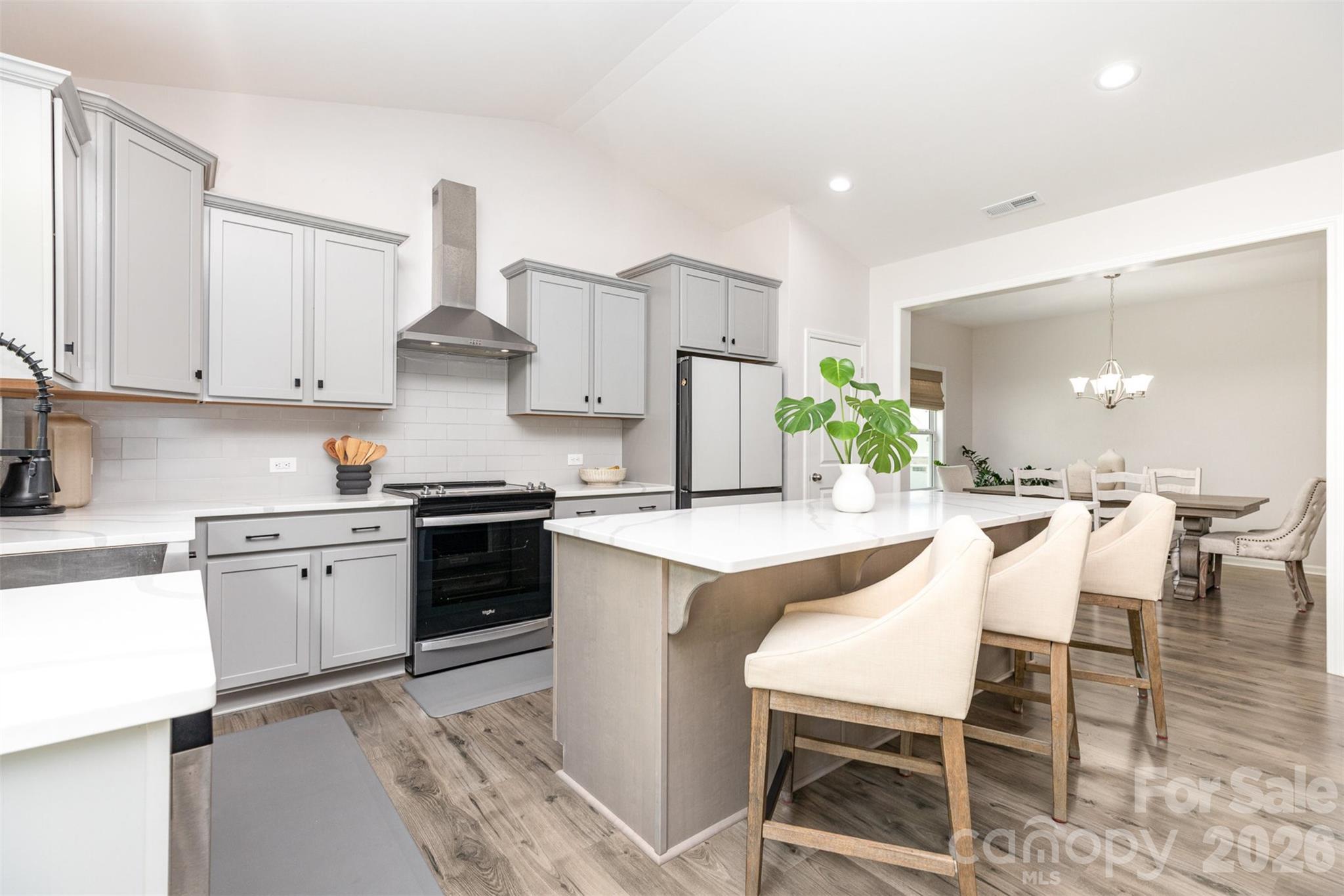 948 Scotch Meadows Loop Monroe, NC 28110 - Photo 12 of 25 a kitchen with stainless steel appliances kitchen island granite countertop a table and chairs in it