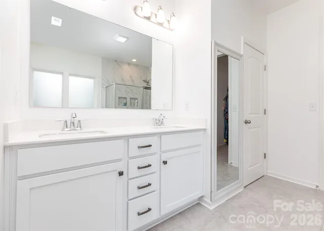a spacious bathroom with a shower sink and mirror