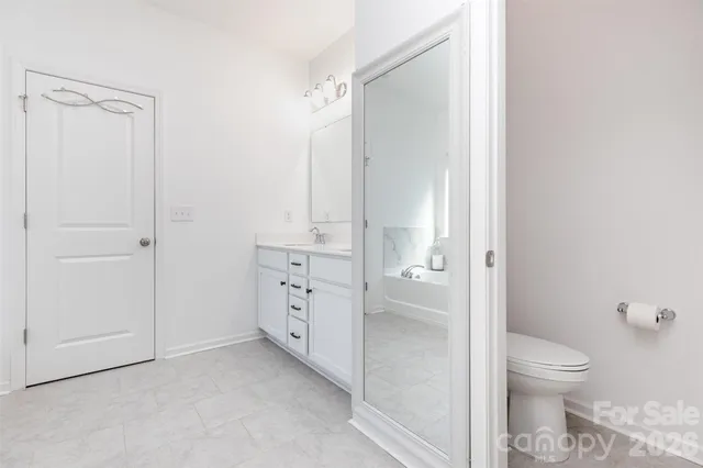 a bathroom with a granite countertop sink a toilet and shower