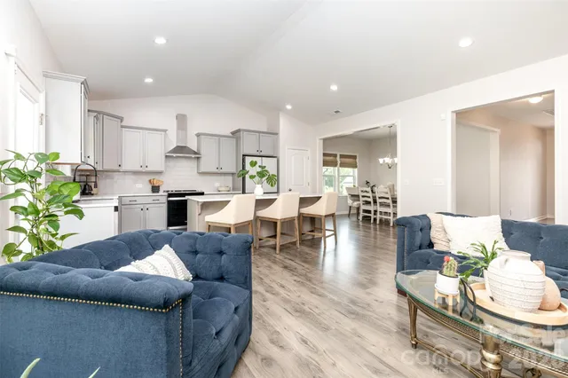 a living room with furniture and a dining table with kitchen view