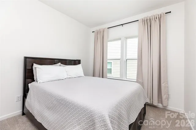 a large bed sitting in a bedroom next to a window