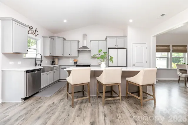 a kitchen with a dining table chairs and white cabinets