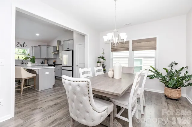 a dining room with furniture potted plants and wooden floor