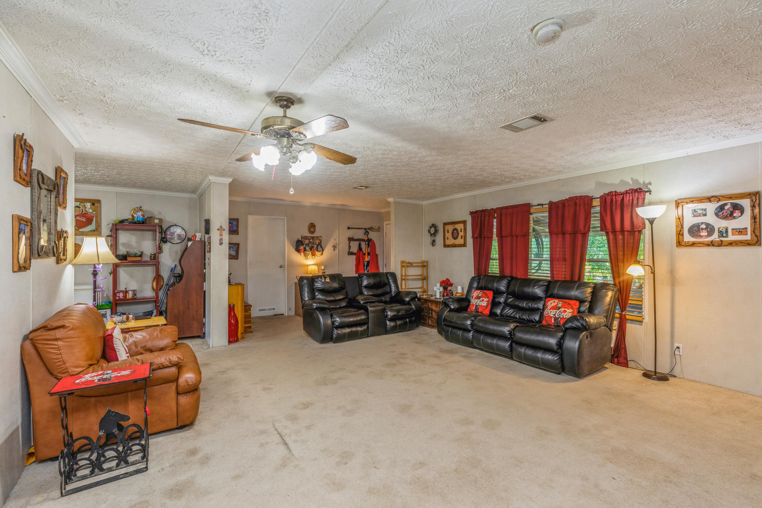 8495 Creston Barrow Road Baker, FL 32531 - Photo 11 of 35 a living room with furniture a ceiling fan and a window