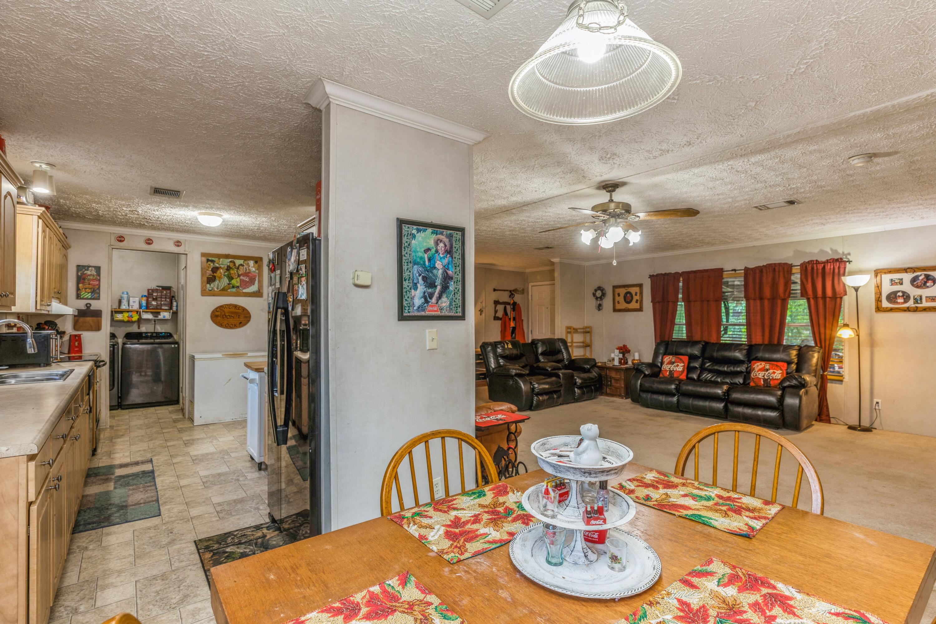 8495 Creston Barrow Road Baker, FL 32531 - Photo 17 of 35 a living room with furniture kitchen and a chandelier