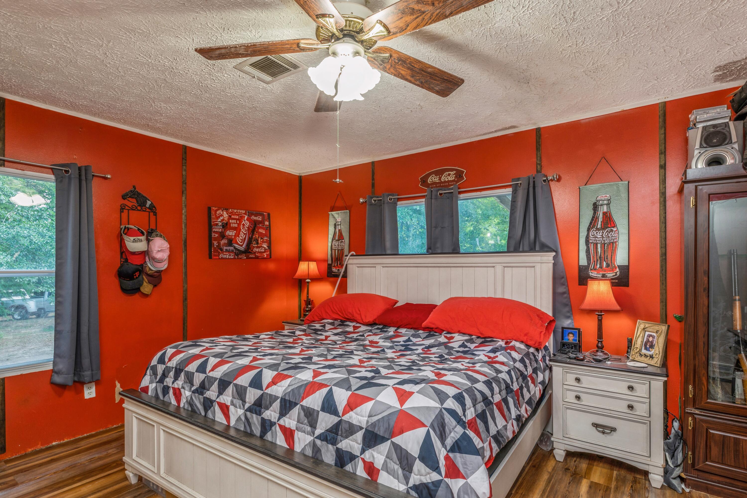 8495 Creston Barrow Road Baker, FL 32531 - Photo 19 of 35 a bedroom with a bed and wooden floor
