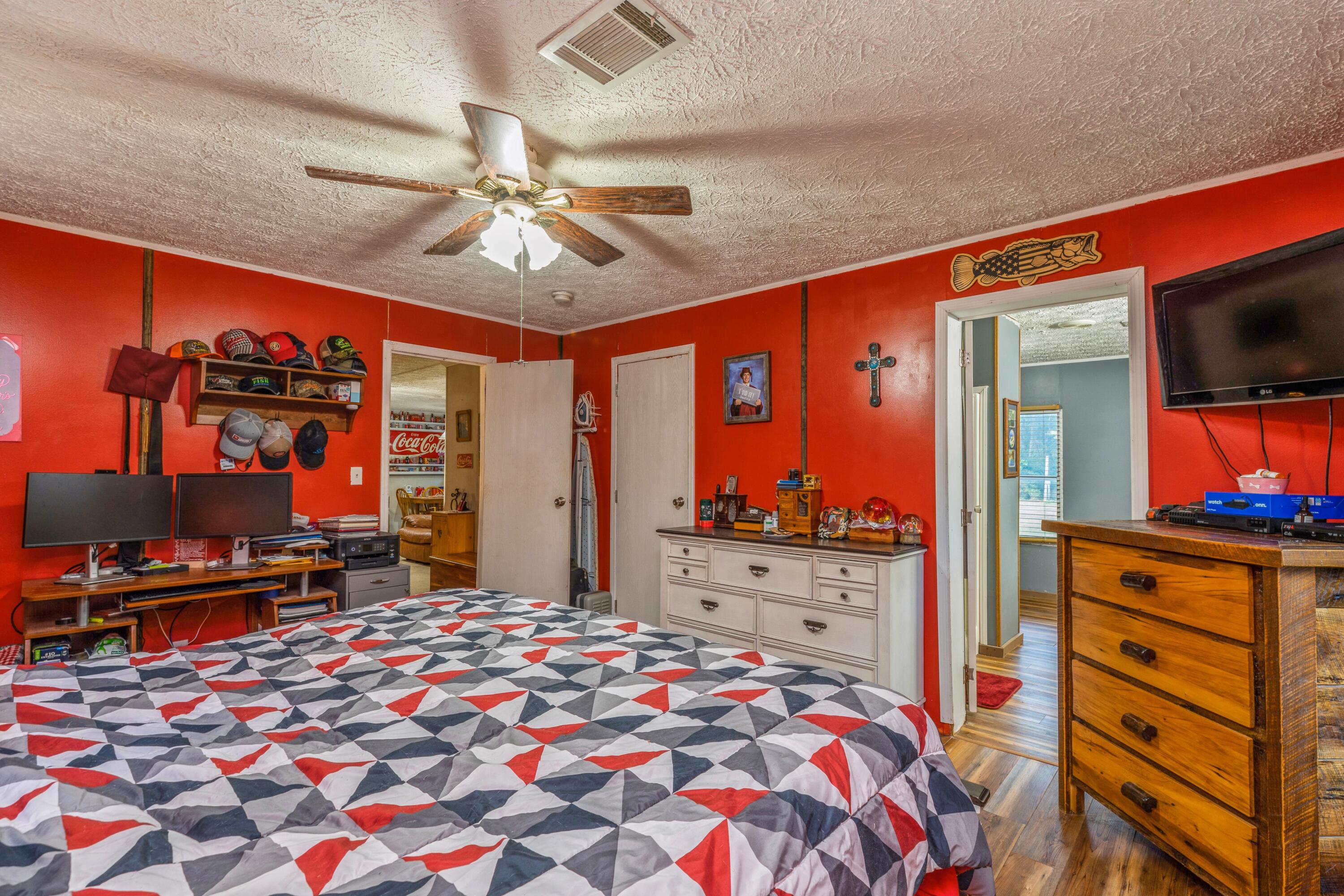 8495 Creston Barrow Road Baker, FL 32531 - Photo 21 of 35 a bedroom with a bed and a flat tv screen on dresser