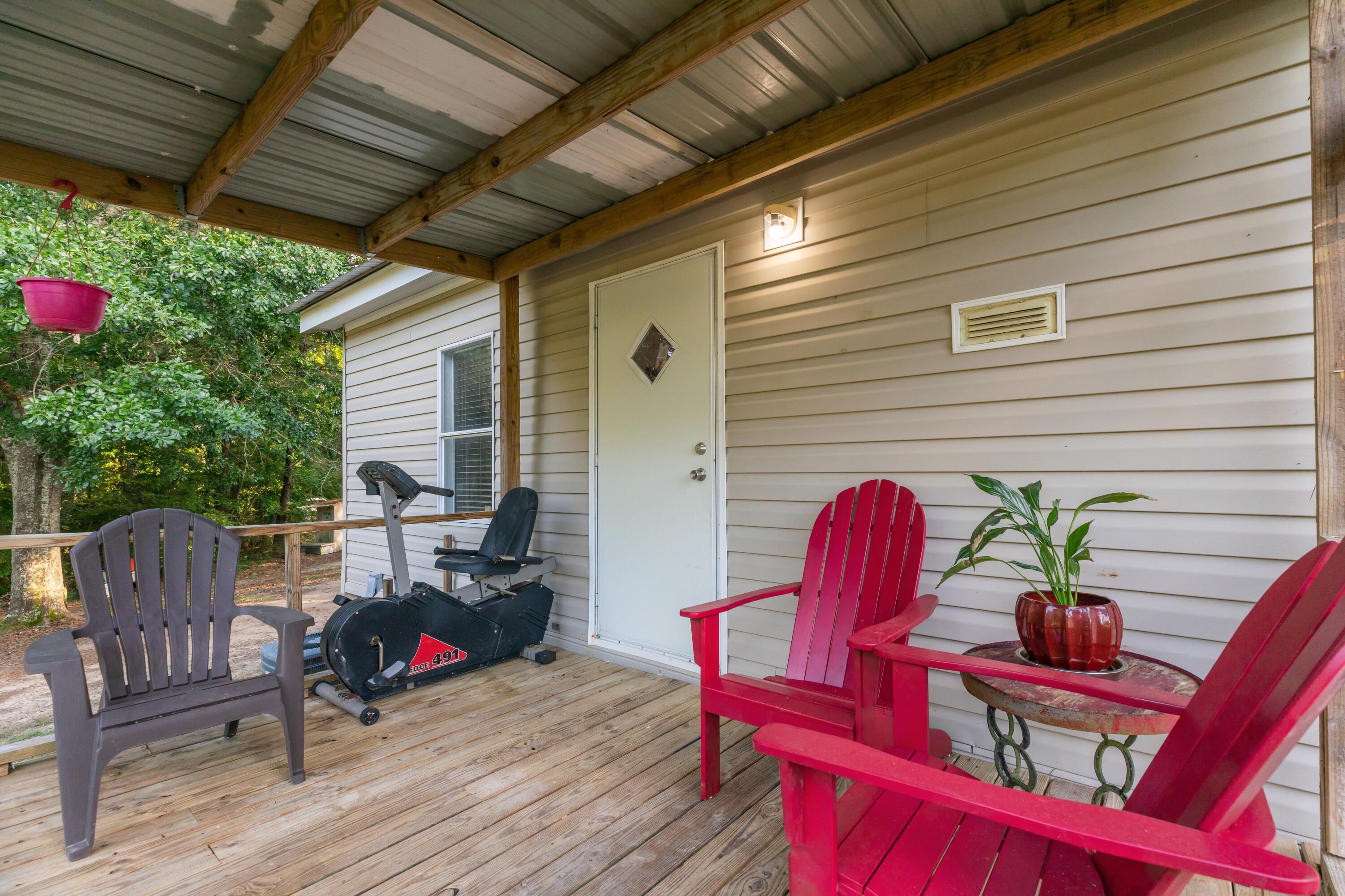 8495 Creston Barrow Road Baker, FL 32531 - Photo 29 of 35 a roof deck with a table and chairs and potted plants