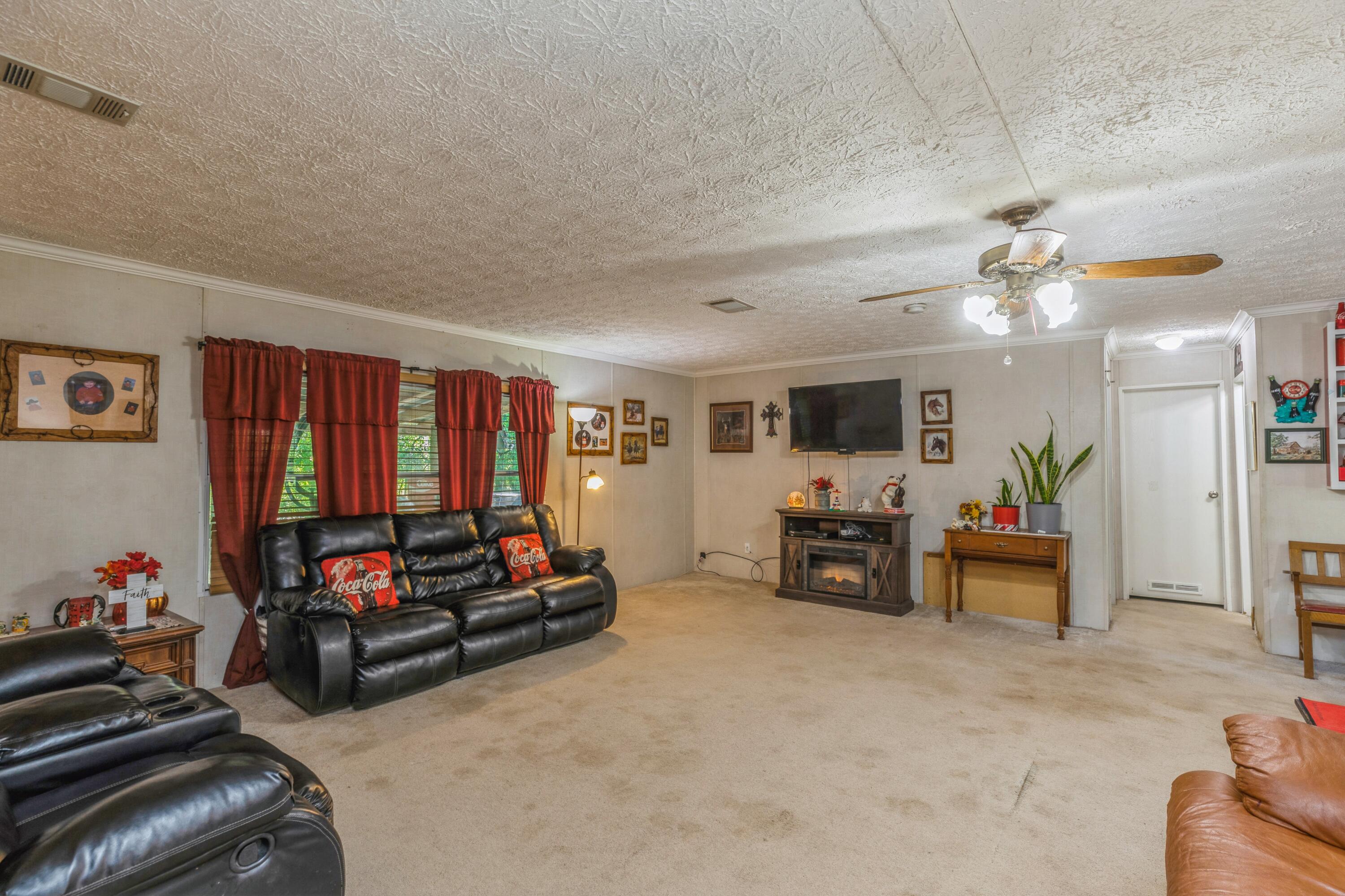 8495 Creston Barrow Road Baker, FL 32531 - Photo 9 of 35 a living room with furniture and a flat screen tv