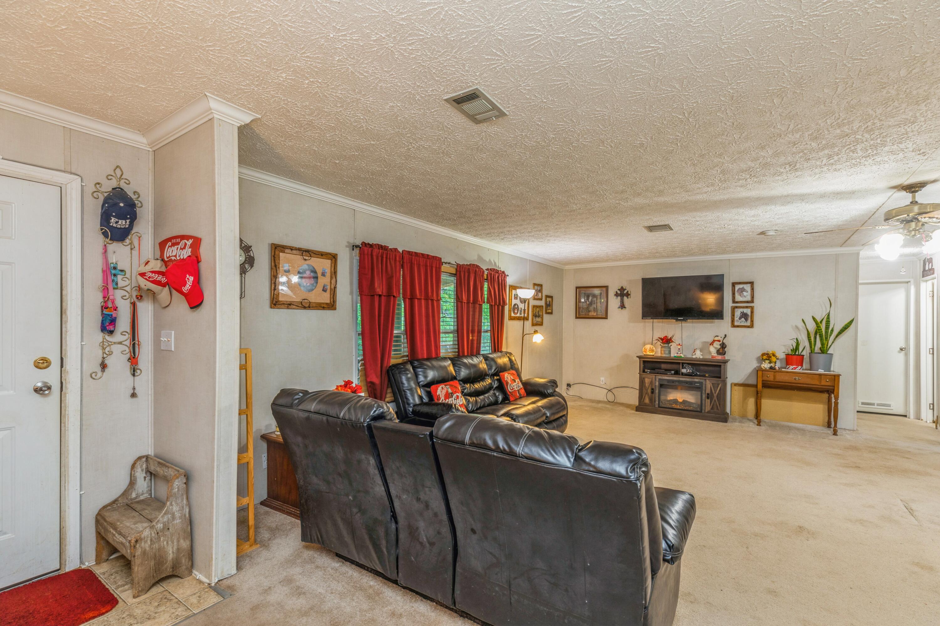 8495 Creston Barrow Road Baker, FL 32531 - Photo 10 of 35 a living room with furniture and a flat screen tv