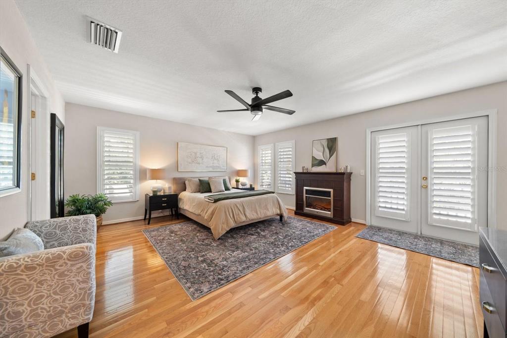 291 1st Avenue Southwest Largo, FL 33770 - Photo 43 of 83 a bedroom with a large bed a flat tv screen and a fireplace