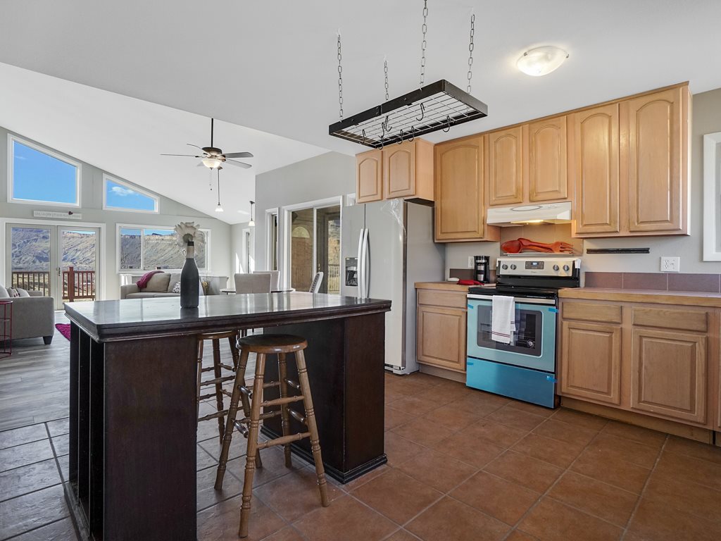 653 39 Road Palisade, CO 81526 - Photo 17 of 35 a kitchen with stainless steel appliances a sink a stove a refrigerator cabinets and chairs