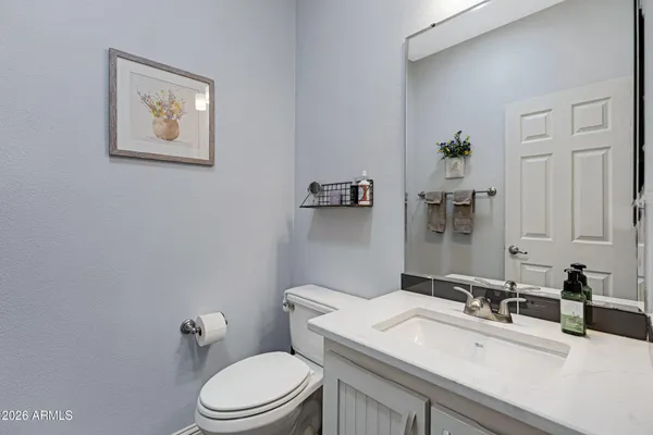 a bathroom with a sink vanity mirror and toilet