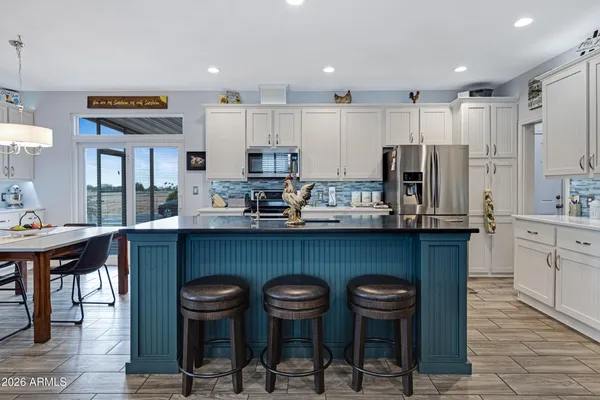 a kitchen with stainless steel appliances a table and chairs in it