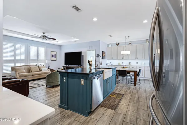 a open kitchen with stainless steel appliances kitchen island granite countertop a sink dishwasher a stove and a refrigerator with wooden floor