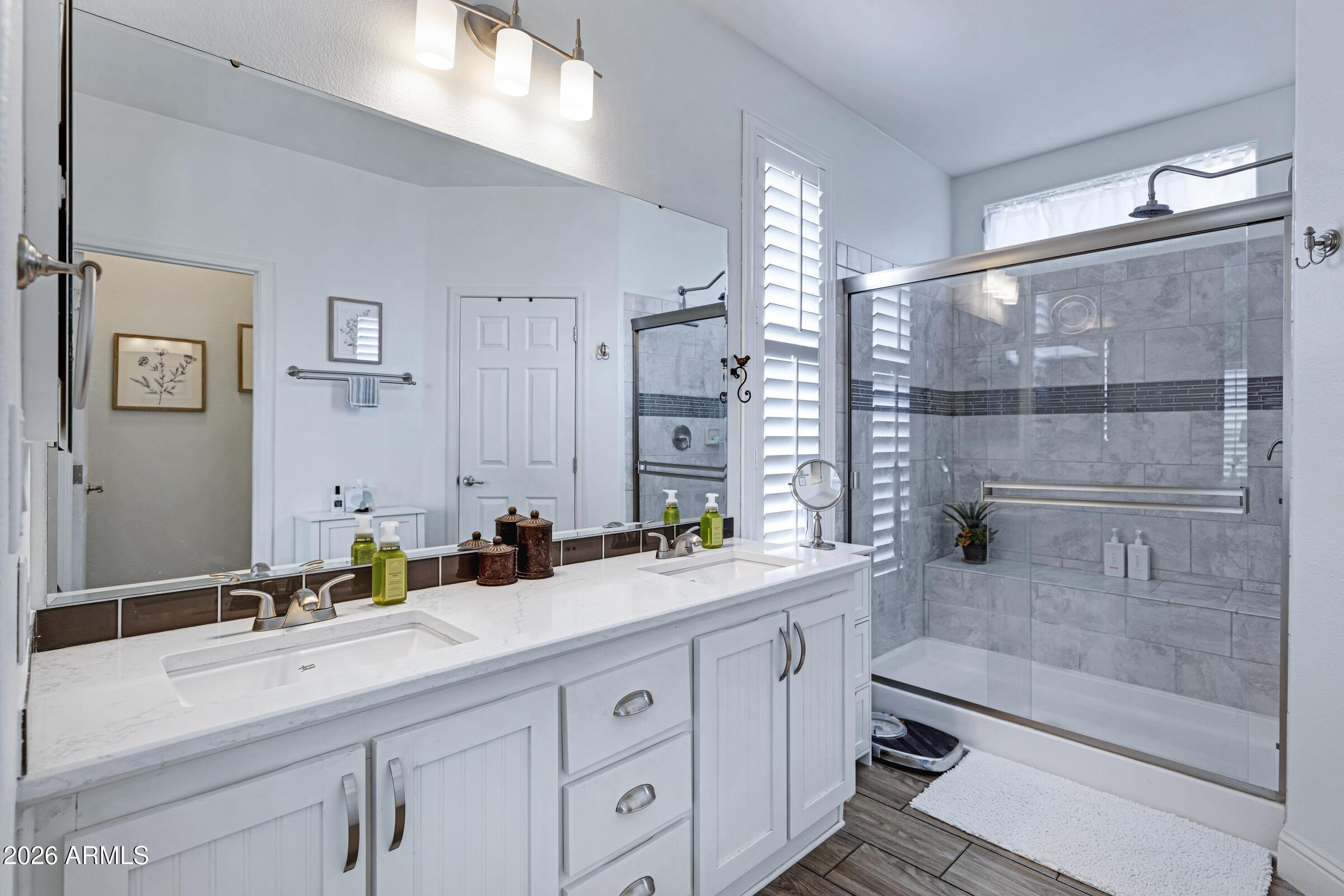 3301 South Goldfield Road, Unit 6055 Apache Junction, AZ 85119 - Photo 23 of 49 a bathroom with a double vanity sink a mirror and a shower