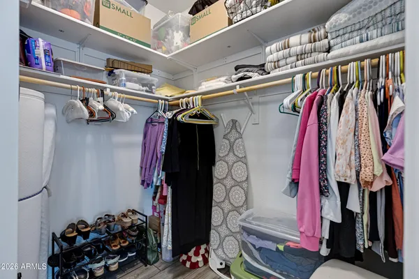 a view of walk in closet with clothes and shoes
