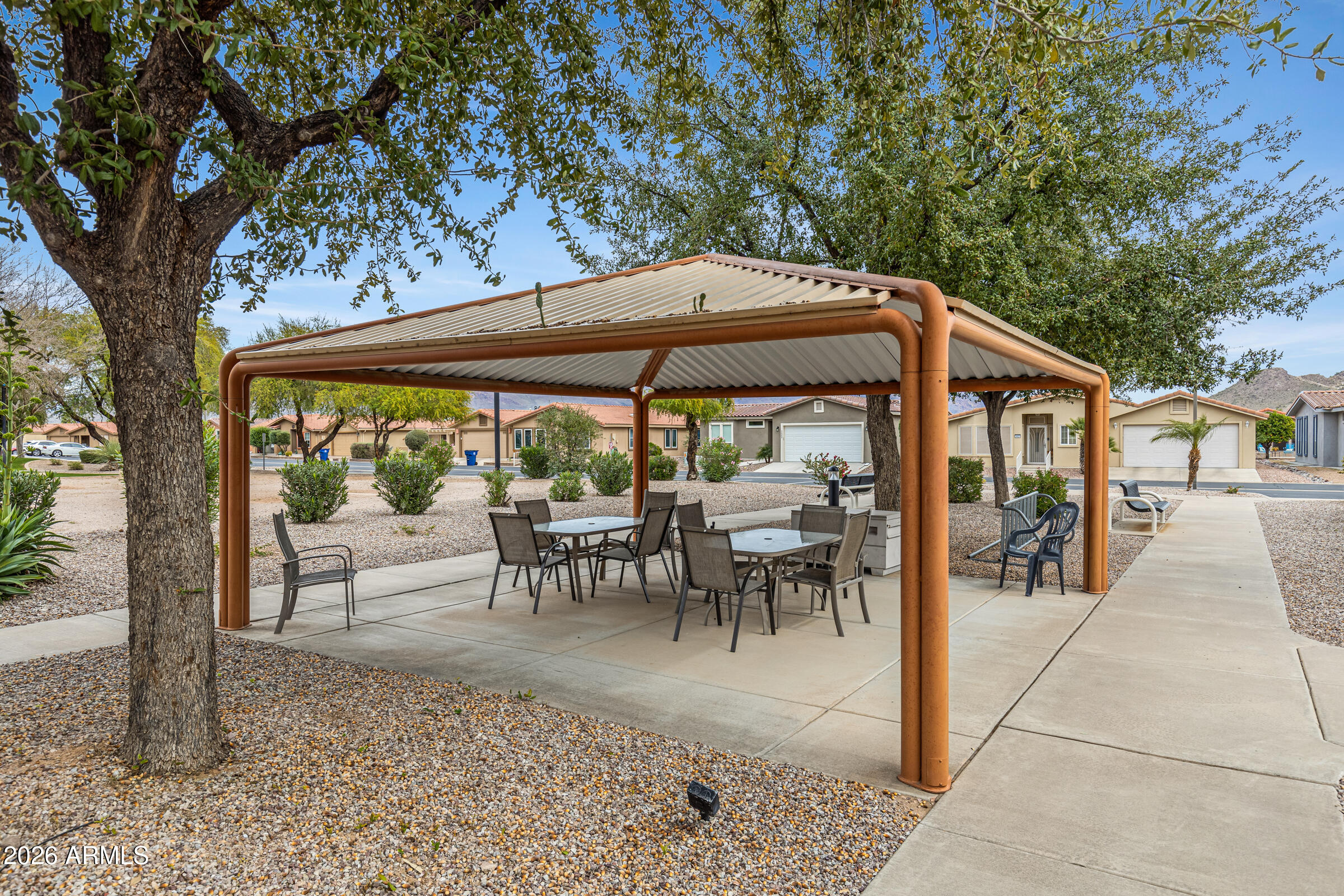 3301 South Goldfield Road, Unit 6055 Apache Junction, AZ 85119 - Photo 39 of 49 a view of a patio with table and chairs under an umbrella
