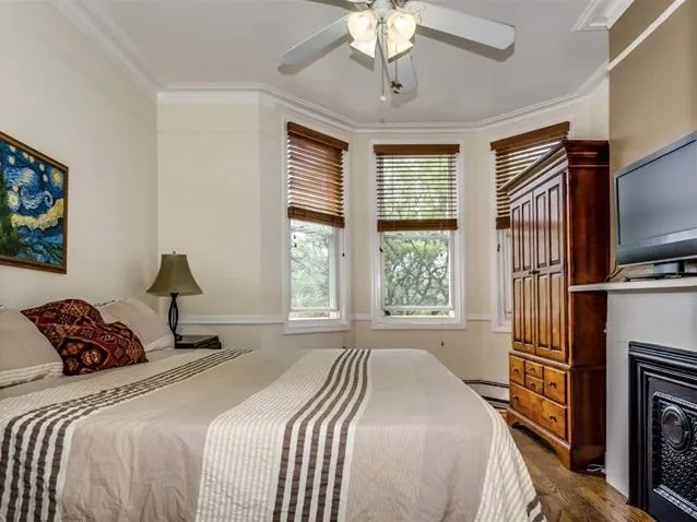 a bedroom with a bed flat screen tv and a large window