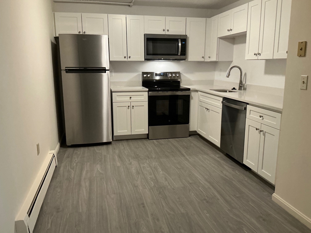a kitchen with a refrigerator sink and white cabinets