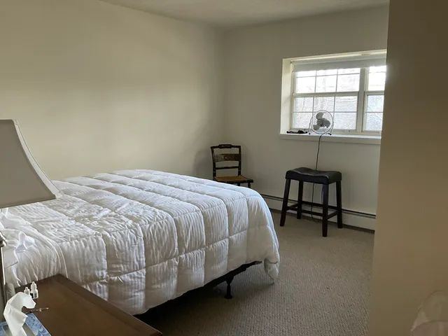 a bed sitting in a bedroom next to a window
