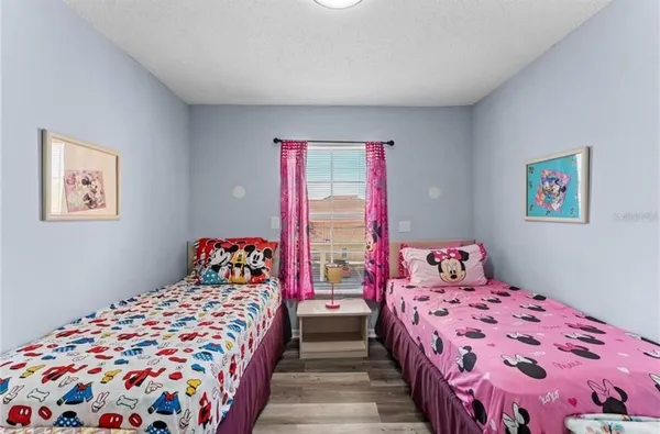 a bedroom with two large bed and a lamp