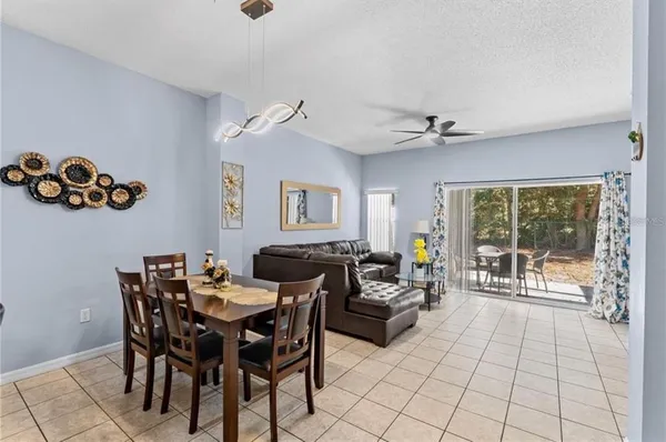 a view of a livingroom and a dining room with furniture wooden floor and a chandelier