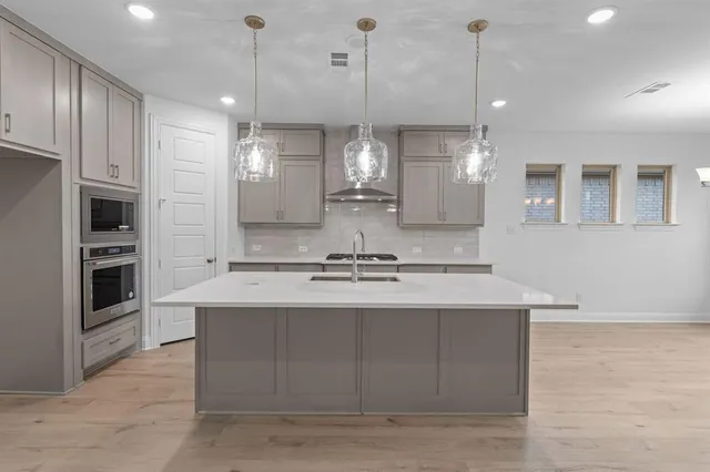 a large kitchen with kitchen island a sink stainless steel appliances and cabinets